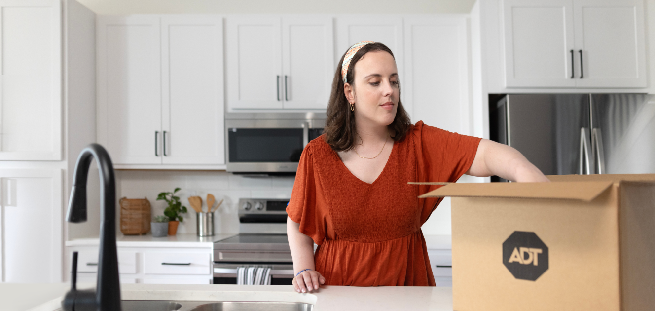 Woman in her home setting up an ADT product