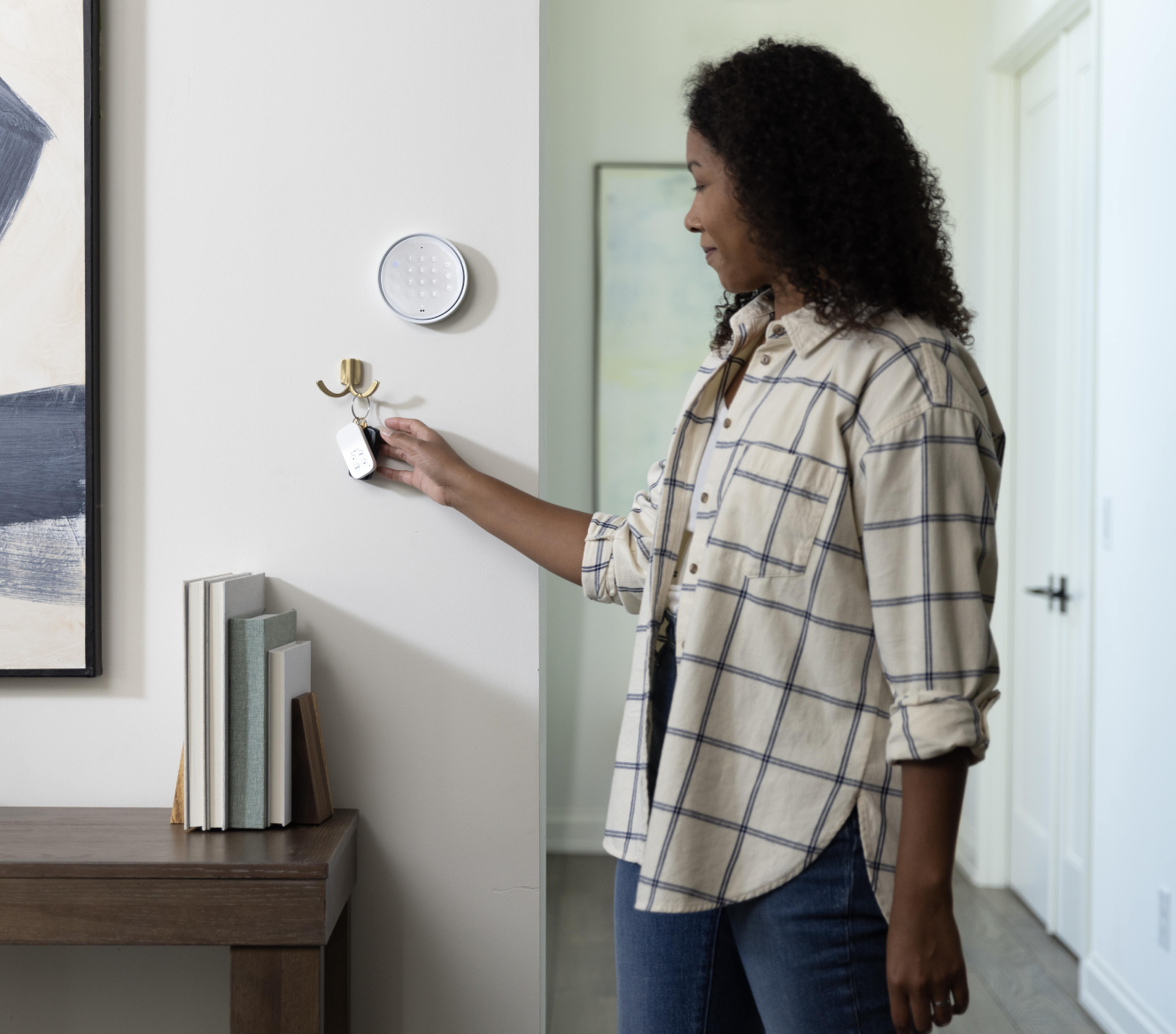 Woman hanging her house keys on a wall next to an ADT Keypad