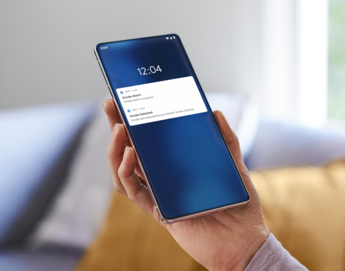Hand holding a phone checking notifications from the ADT app