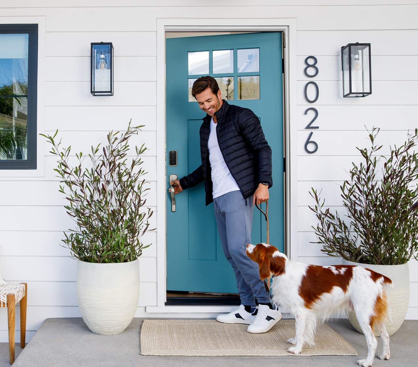 Homeowner with his dog outside of his front door that has a Yale Smart Lock on the door